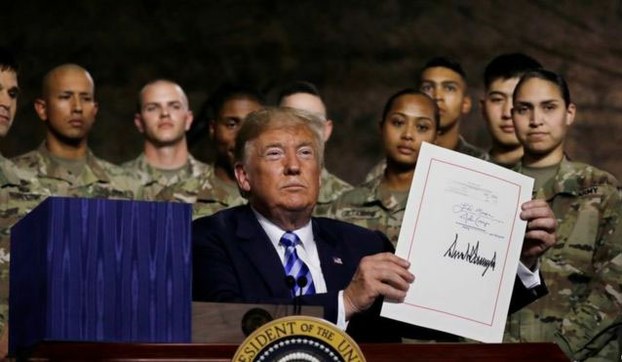 2018年8月13日，美国总统特朗普在纽约州的德拉姆堡军事基地签署《2019年度国防授权法案》 。（路透社）