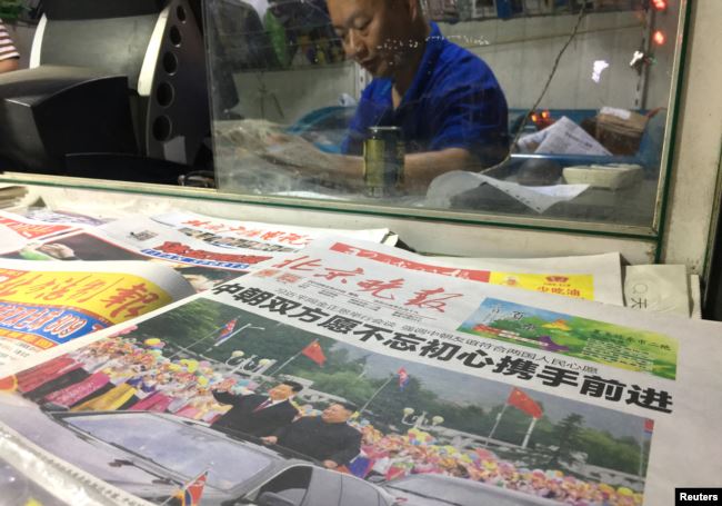 北京街头报摊2019年6月21日出售的北京晚报的头版是中国国家主席习近平与朝鲜领导人金正恩在平壤的大幅照片。