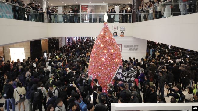 香港抗议者在圣诞节平安夜游行走过一家商场。（2019年12月24日）