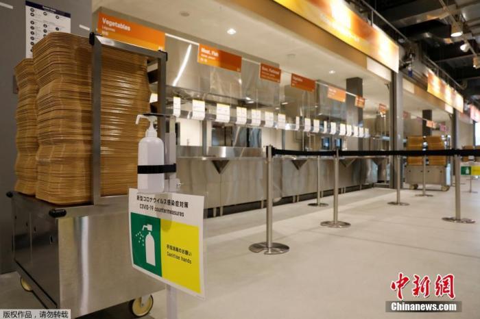 当地时间6月20日，距东京奥运会开幕还有33天时，奥运村首次对媒体开放。图为奥运村餐厅里摆放的洗手液和防疫标识。