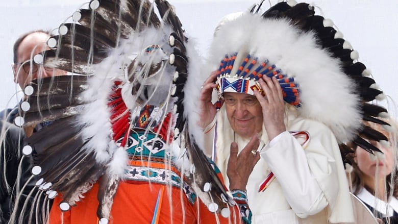 Two men in traditional Indigenous headdresses