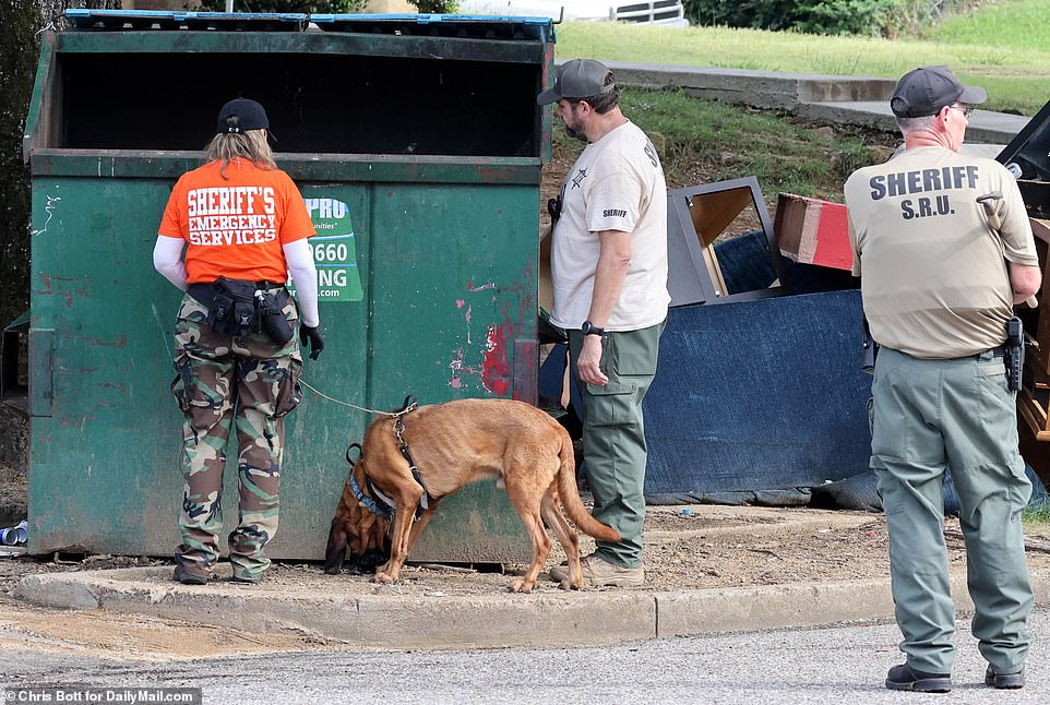 Police sniffer dogs from the Shelby County Sheriff's office working alongside search teams around a dumpster close to Mario Abston's home. The dumpster was later hauled away by police