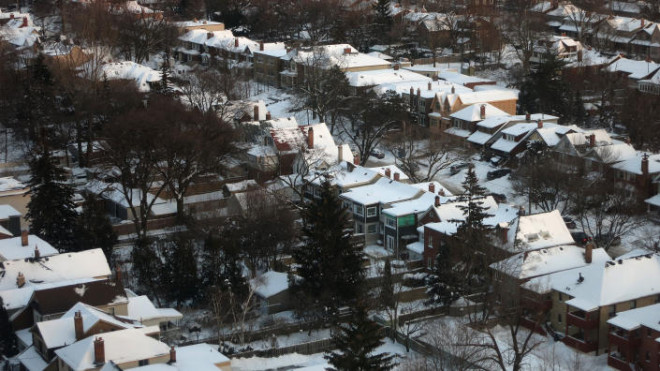 Detached houses covered in snow in a low density suburban residential area.