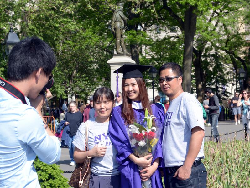 近年中国在美国的留学生人数减少，图为从纽约大学毕业的中国留学生在毕业典礼上与家人...